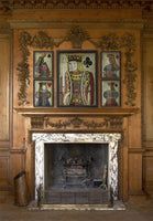 A wooded ornate mantel with one larger Playing Card Art flanked by two smaller playing card art from Interior Mojo.