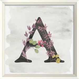 A set of three framed artworks with the letters 'K', 'A', and 'T' displayed on a wall above a white crib in a nursery room.